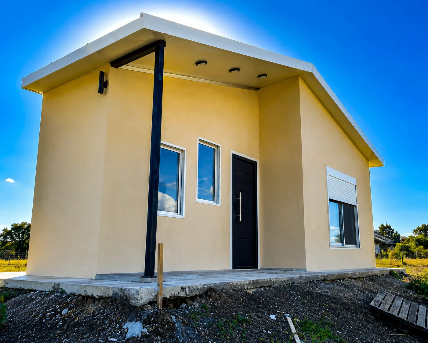 Casa de isopanel color mostaza, fachada con columna metálica.