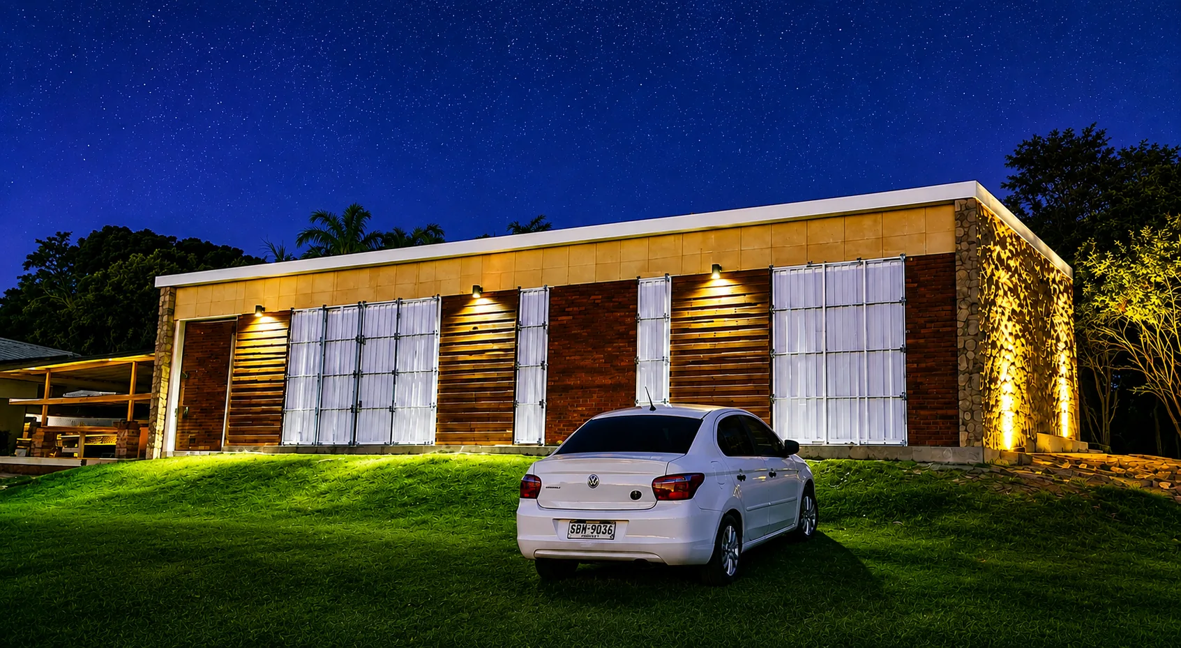 Casa de isopanel de noche, con iluminación arquitectónica cálida.